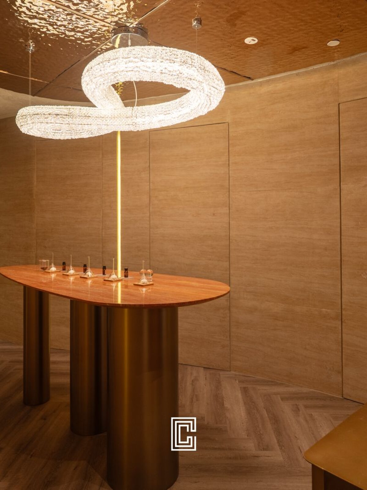 Timber-lined room with a circular ring pendant suspended over a slim oval table